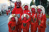 Während die Erwachsenen eine Holzmaske tragen, werden Kinder sorgfältig rot-schwarz nach den Vorgaben des Vereins geschminkt. Sie tragen eine rote Strickmütze (Schlupfmütze) mit auf rotem Tuch aufgenähter Büffelhaarmähne und Kinderkrone.