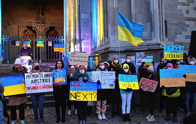 Samstagabend vor dem Münsterportal: Junge Menschen aus der Ukraine demonstrierten mit Plakaten und Reden gegen den Krieg in ihrem Land. Am Rednerpult ist der Konstanzer Politikwissenschaftler Wolfgang Seibel zu sehen.
